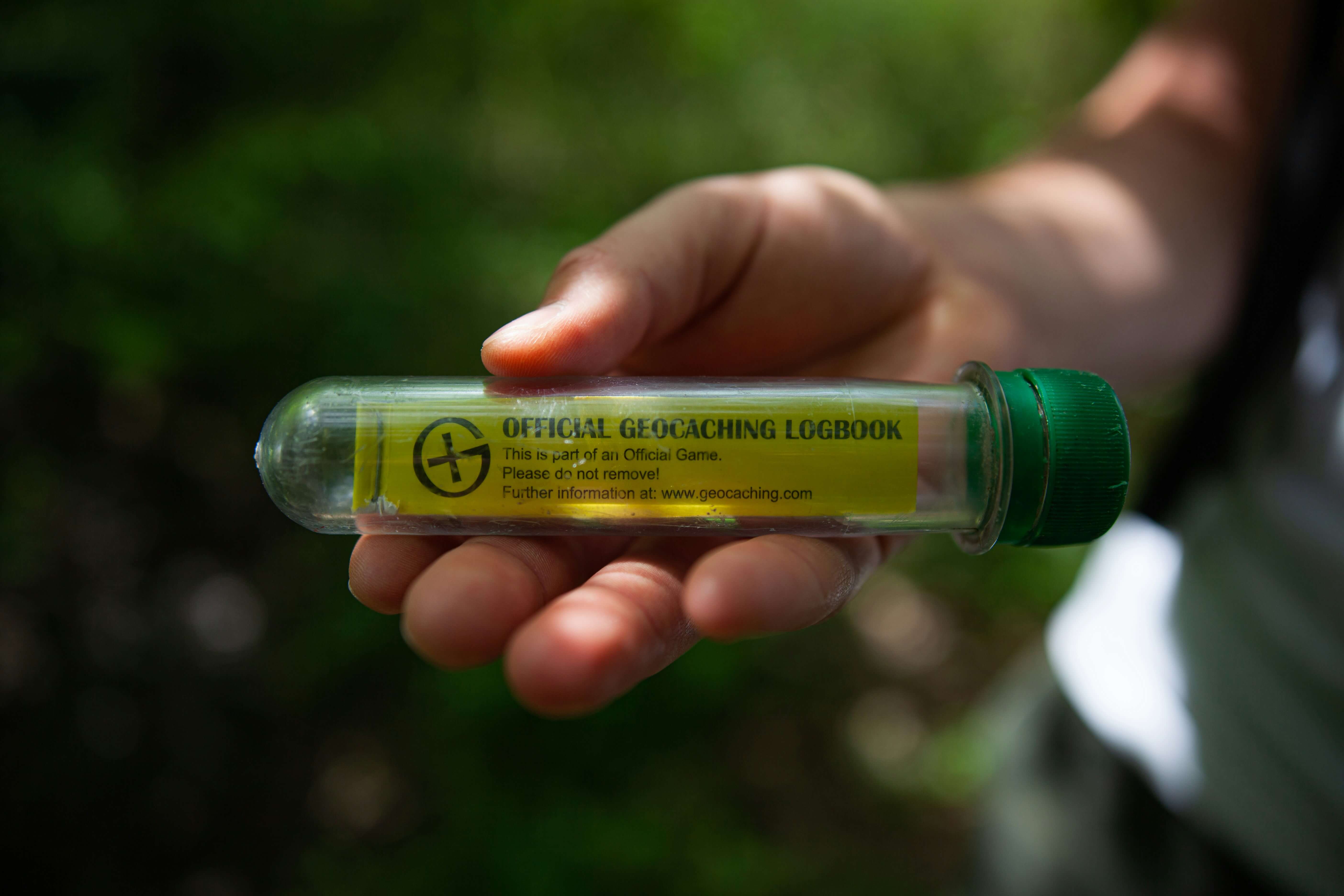 a hand holding a geocache